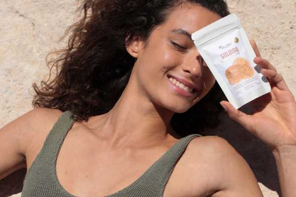 jeune femme montrant un sachet de complexe solaire